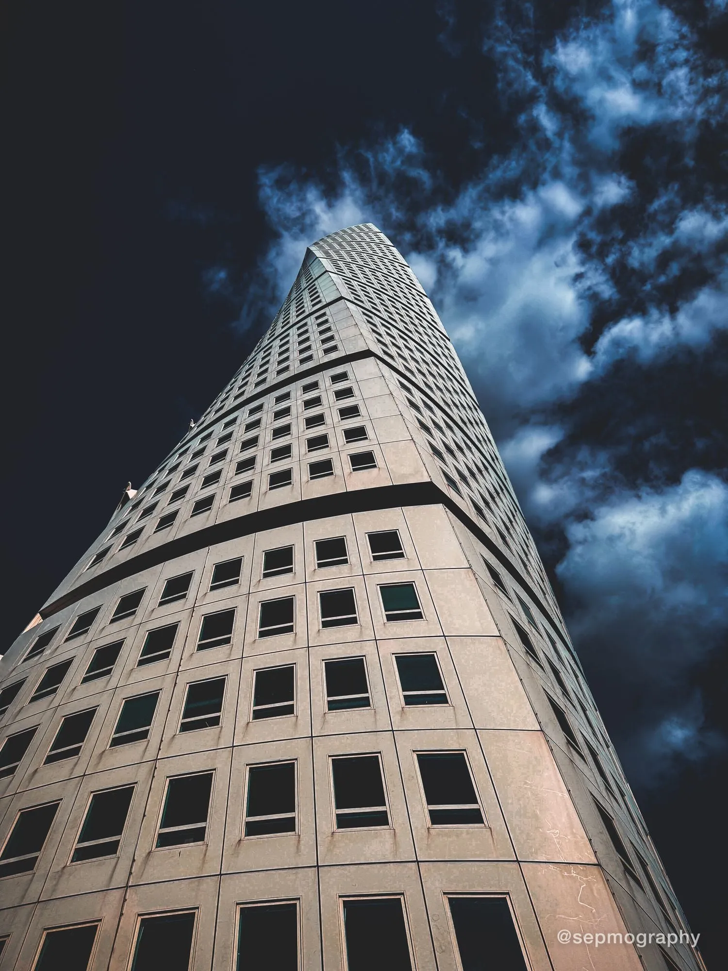The Turning Torso tower seen from its base, twisting into a dark sky