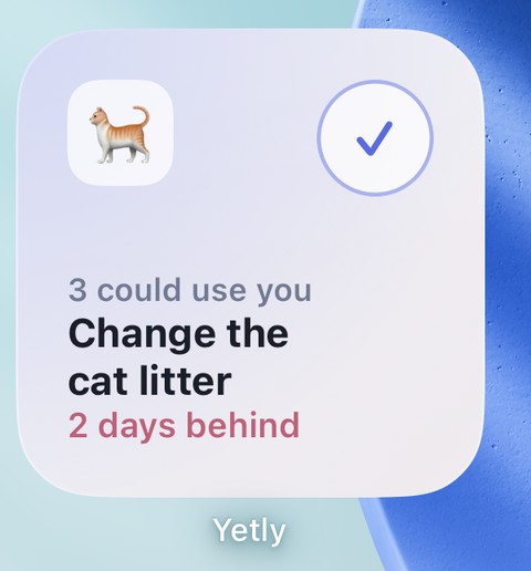 The small Yetly widget on an iPhone home screen. It reads 3 could use you, change the cat litter, 2 days behind, with a cat icon and a tick to mark it done.